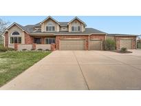 Charming two-story brick home with a spacious three-car garage and a well-maintained lawn at 19770 E Geddes Pl, Centennial, CO 80016