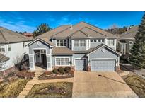 Charming two-story home with a well-manicured lawn, mature landscaping, and a two-car garage at 10040 Longview Dr, Lone Tree, CO 80124