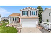 Charming two-story home featuring a well-manicured lawn and inviting front porch at 9651 Bighorn Way, Littleton, CO 80125