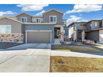 Inviting two-story home with a two car garage and manicured lawn on a beautiful day at 1526 Golden Sill Dr, Castle Pines, CO 80108