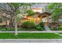 Charming stucco home featuring manicured landscaping, covered entryway, and inviting curb appeal at 7444 E 9Th Ave, Denver, CO 80230