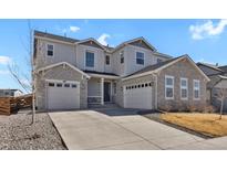 Charming two-story home featuring stone accents, three-car garage, and a well-maintained front yard at 1180 Ascent Trail Cir, Erie, CO 80516