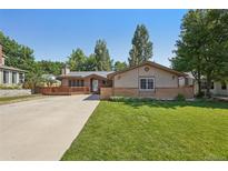 Charming single-story home featuring a spacious front yard, lovely wood deck, and well-maintained landscaping at 215 Sunland St, Louisville, CO 80027