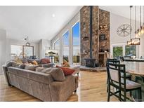 Bright living room with large windows, a stone fireplace, hardwood floors, and an open floor plan at 1758 Sinton Rd, Evergreen, CO 80439