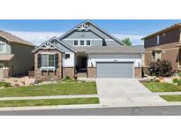 Charming two-story home featuring stone accents, a well-manicured lawn, and an attached two-car garage at 12189 Windy Trail Ln, Parker, CO 80138
