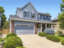 Charming two-story home features a well-manicured front yard and attached two car garage at 9625 S Hackberry St, Highlands Ranch, CO 80129