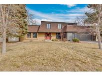 Charming two-story home with a red front door, mature trees, and a well-maintained lawn at 2496 S Leyden St, Denver, CO 80222