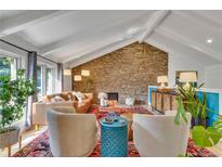 Inviting living room with vaulted ceilings, stone accent wall, and comfortable seating arrangement at 2496 S Leyden St, Denver, CO 80222