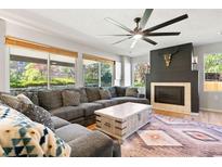 Inviting living room features a fireplace and a large window with a view of the backyard at 8288 W Chestnut Ave, Littleton, CO 80128