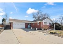 Charming single-story brick home featuring an attached two-car garage and a well-maintained front yard at 343 Melody Dr, Northglenn, CO 80260