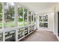 The sunroom offers large windows with expansive green outdoor views and a private entry at 650 S Alton Way # 10A, Denver, CO 80247