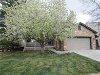 Charming stone home with a flowering tree, two car garage, and manicured lawn at 10522 Stoneflower Dr, Parker, CO 80134