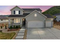 Charming two-story home featuring a three-car garage, inviting porch, and beautiful, low-maintenance landscaping at 5446 Mesa Top Dr, Monument, CO 80132