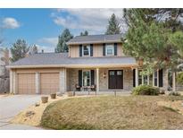 Charming two-story home with a well-manicured lawn, an attached two-car garage, and classic brick and siding details at 7748 S Valentia St, Centennial, CO 80112