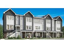 Modern townhouse exterior featuring a stylish combination of gray siding and brick accents at 694 Saddle Dr, Erie, CO 80516