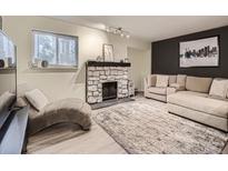 Inviting living room featuring a stone fireplace, neutral color palette, and comfortable seating arrangement at 4068 S Atchison Way # 101, Aurora, CO 80014