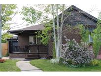 Charming brick home with mature trees, lush landscaping and inviting front porch at 1363 Stuart St, Denver, CO 80204