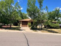 Charming single-story home with a driveway, mature trees, and a well-maintained lawn at 6139 S Adams Dr, Centennial, CO 80121