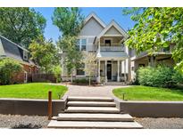 Inviting two-story home featuring a covered front porch and meticulously maintained lawn at 321 S Emerson St, Denver, CO 80209