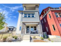 Modern exterior showcases a gray facade with stone accents and a cozy front porch at 8795 Hugo Dr, Littleton, CO 80125