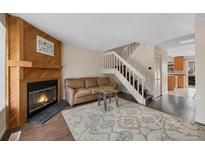 Inviting living room features a cozy fireplace, warm wood accents, and a staircase at 17151 E Stanford Ave # B, Aurora, CO 80015