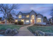 Elegant two-story home with a brick walkway and manicured front lawn at dusk at 8 Mountain Willow Dr, Littleton, CO 80127