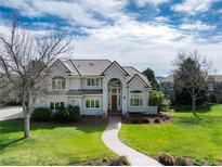 Stunning two-story home with arched entry, well-manicured lawn, and beautiful landscaping at 8 Mountain Willow Dr, Littleton, CO 80127