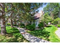 Charming exterior of home with a well-maintained lawn and lovely trees at 943 S Fairplay St, Aurora, CO 80012