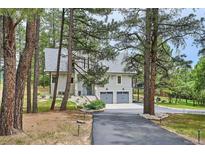Charming gray home featuring an attached two-car garage and an asphalt driveway at 7312 Marshall Rd, Larkspur, CO 80118