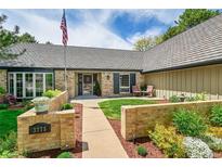 Charming brick home with well-manicured lawn, beautiful landscaping, and cozy outdoor seating area at 3775 S Poplar St, Denver, CO 80237