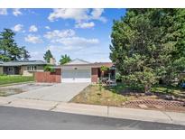 Charming brick home with an attached garage and driveway, lush lawn, and mature trees at 3871 W Saratoga Ave, Littleton, CO 80123