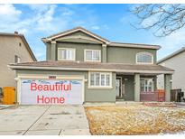 Charming two-story home with landscaped yard, a front porch, and an attached two-car garage at 19731 E 40Th Ave, Denver, CO 80249