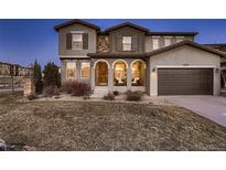 Charming home featuring a covered porch with stone accents and a two-car garage at 2618 S Kilmer Ct, Denver, CO 80228