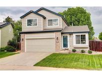 Charming two-story home with a well-manicured lawn, attached garage, and inviting blue trim at 21486 E Crestline Ln, Centennial, CO 80015
