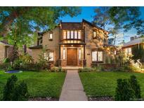 Charming two-story home with stone accents, landscaped yard, and a welcoming walkway leading to the front door at 718 Locust St, Denver, CO 80220