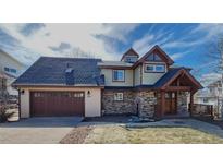 Charming two-story home featuring stone accents, a two-car garage, and a welcoming covered front porch at 2418 W Euclid Ave, Littleton, CO 80120