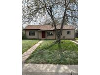 Charming single-story home featuring a well-maintained lawn, mature shade tree and a inviting red front door at 2865 S Fairfax St, Denver, CO 80222