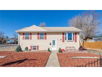 Charming two-story home featuring light-colored siding, red shutters, and a well-maintained front yard with mulch at 381 El Paso Ct, Denver, CO 80221