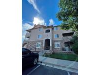 Beautiful condo building with stone accents and a well-maintained lawn on a sunny day at 9557 W San Juan Cir # 207, Littleton, CO 80128