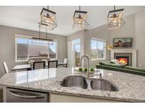 Modern kitchen with granite countertops, stainless steel sink, and pendant lighting at 17124 Mariposa St, Broomfield, CO 80023