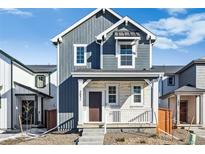 Charming two-story home boasts stone accents, covered porch, and a well-maintained front yard at 2031 Generations Aly, Brighton, CO 80601