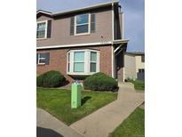 Charming townhome with a brick facade, bay window, and well-manicured landscaping in a residential neighborhood at 16485 E 17Th Pl # D, Aurora, CO 80011