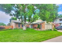 Charming brick home featuring a lush lawn, mature tree, and inviting curb appeal at 8561 E Grand Ave, Denver, CO 80237