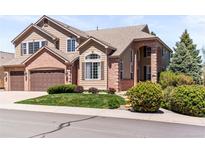 Charming two-story home featuring a brick and siding facade with a well-maintained lawn and mature landscaping at 1845 Cuprite Ct, Castle Rock, CO 80108