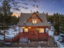 Charming cabin with a front porch and wooded scenery, perfect for peaceful mountain living at 439 Ronnie Rd, Golden, CO 80403