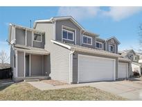 Two story house with a two car garage, number 879 on the side of the gray siding at 879 Canary Ln, Brighton, CO 80601