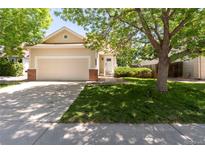 Charming home with mature trees, well-manicured lawn, and a two-car garage at 12666 Davis St, Broomfield, CO 80020