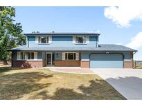 Charming two-story home boasts a well-manicured lawn and a welcoming brick facade at 12579 Appaloosa Pl, Broomfield, CO 80020