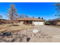 Charming single-story home with a brick facade, landscaped front yard, and a two-car garage at 6505 W 46Th Pl, Wheat Ridge, CO 80033