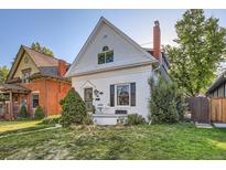 Charming two-story home featuring a brick chimney, updated windows, and a well-maintained lawn at 1006 S Emerson St, Denver, CO 80209